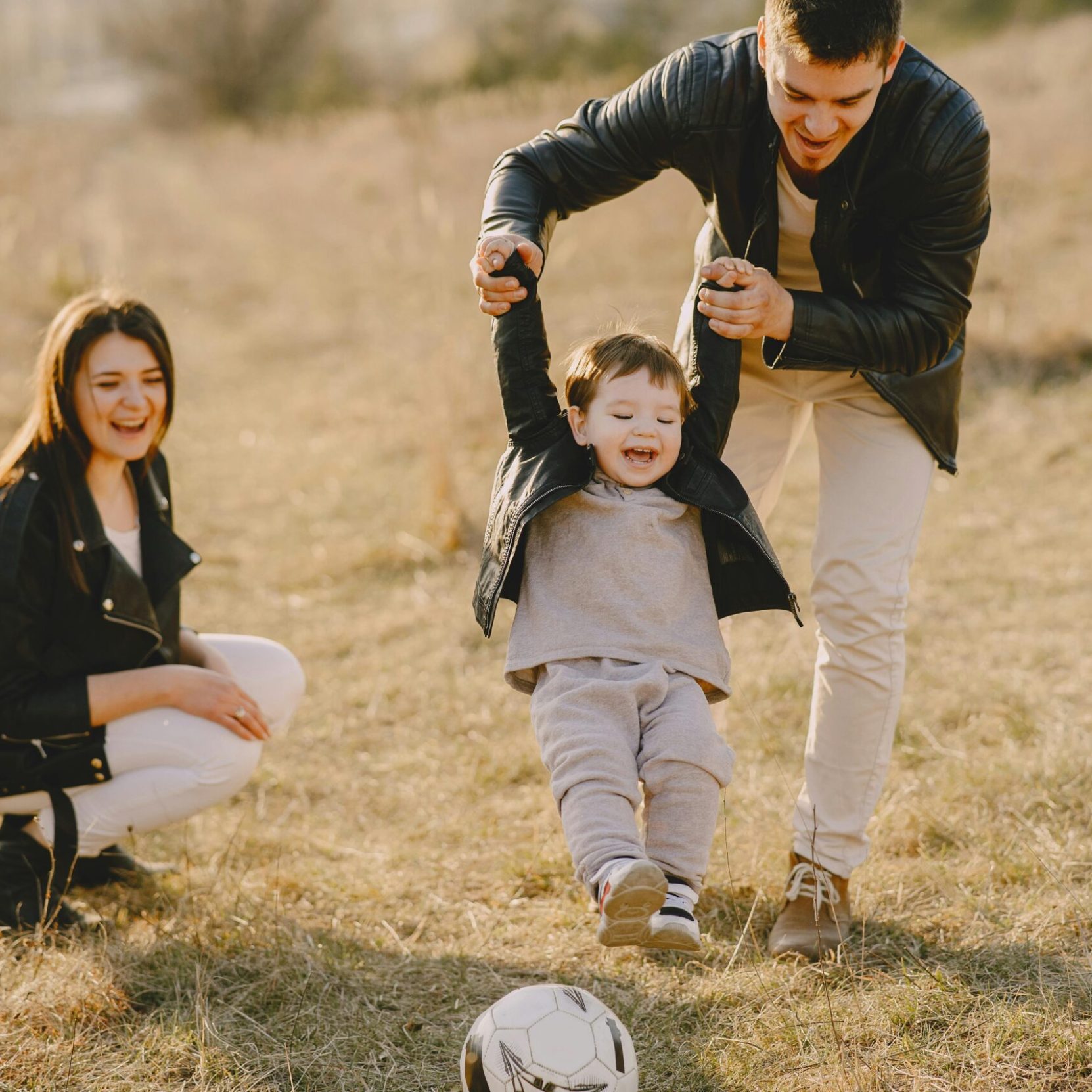 Family enjoying playful soccer game outdoors, capturing joyful moments.